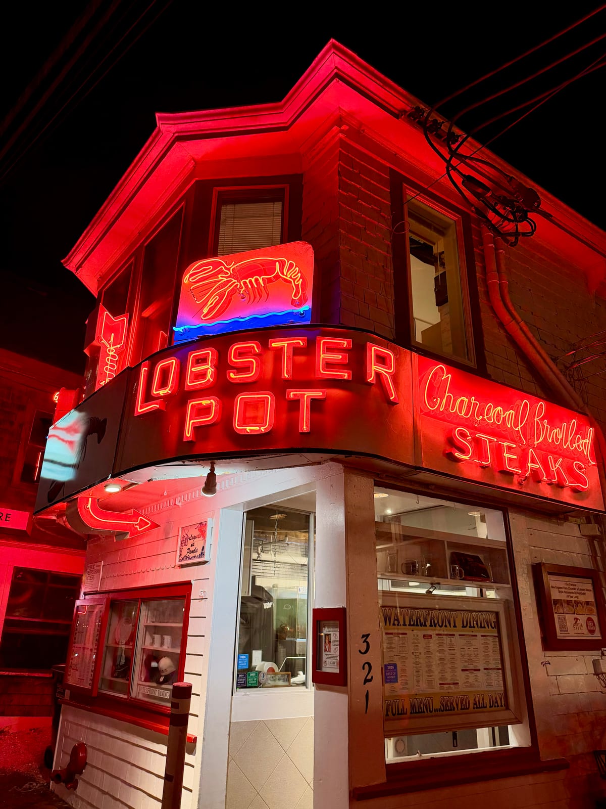 The Lobster Pot restaurant glowing with vivid red neon at night