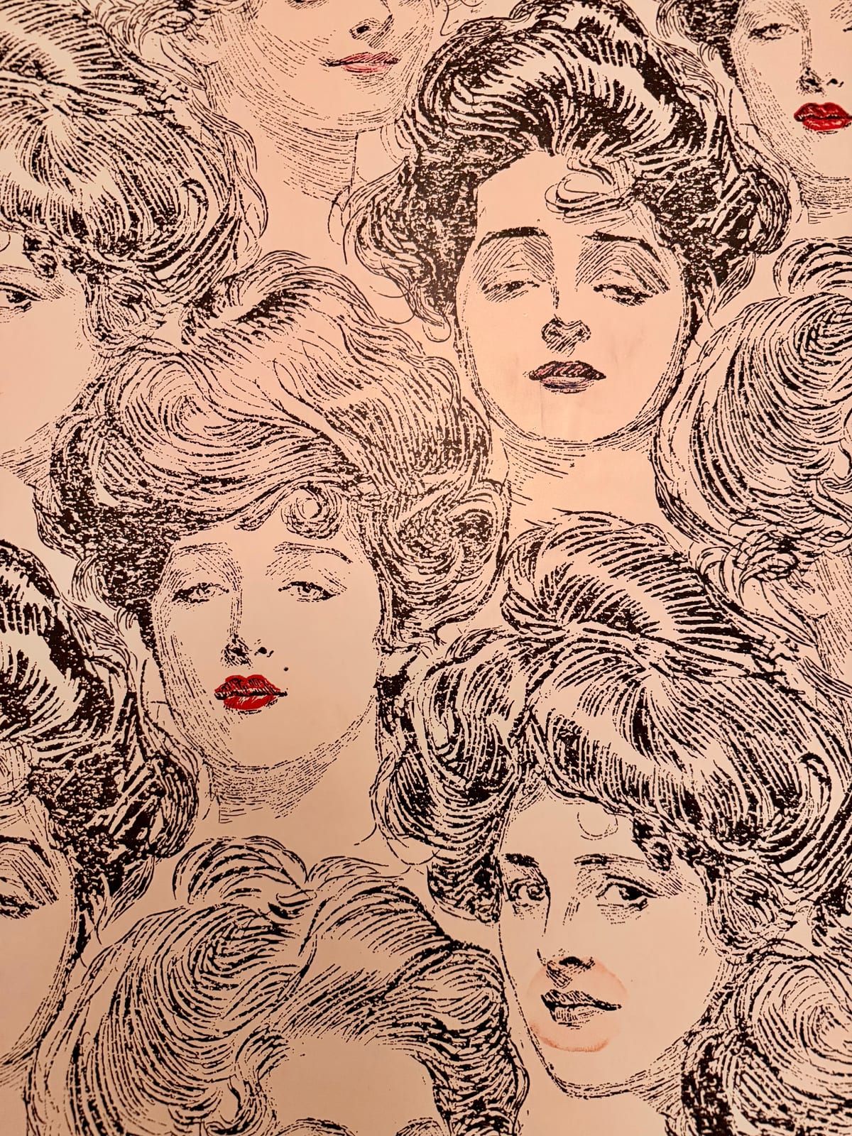An illustrated wall of expressive faces with a few bright red lips