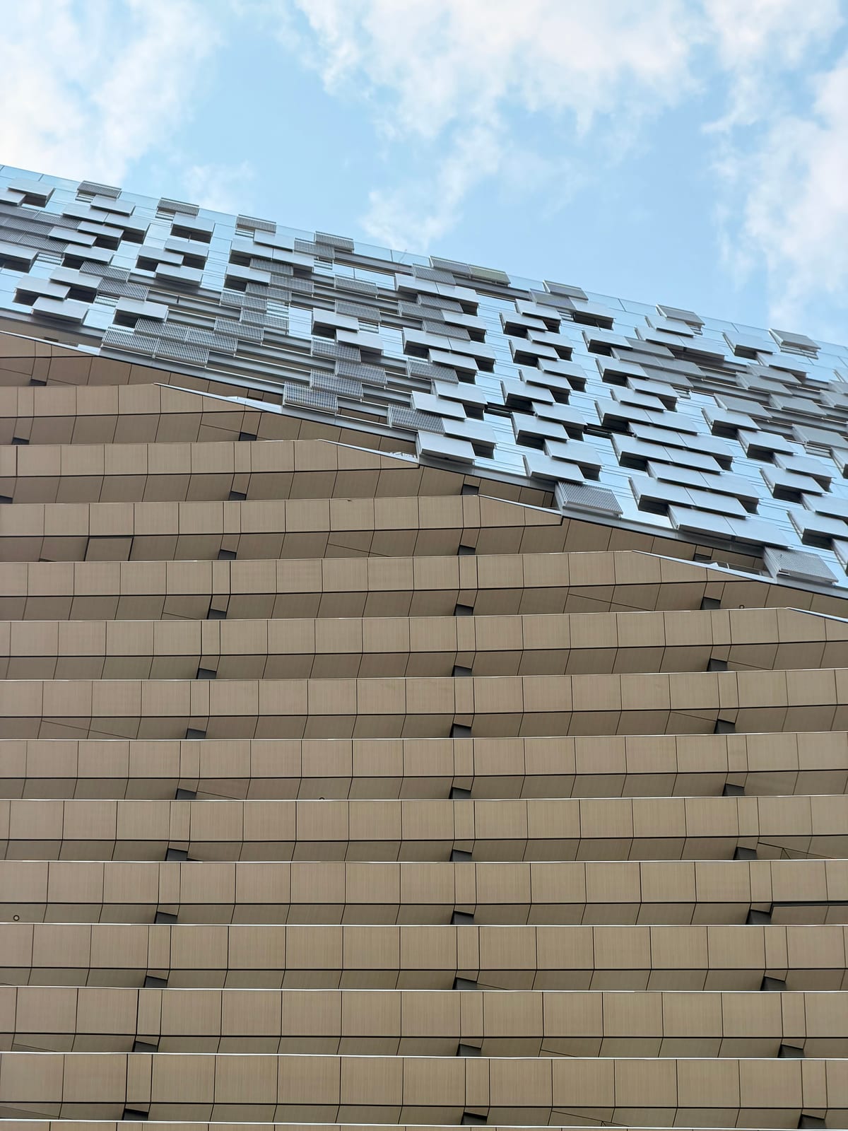 A modern Vancouver building with layered metallic panels beneath a blue sky